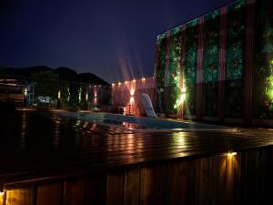 a building with a swimming pool at night at Pousada do Francês in Ubatuba