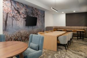 a conference room with tables and chairs and a tv on a wall at Fairfield by Marriott Inn & Suites Corbin in Corbin
