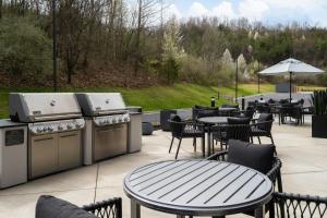 a patio with a grill and tables and chairs at Fairfield by Marriott Inn & Suites Corbin in Corbin