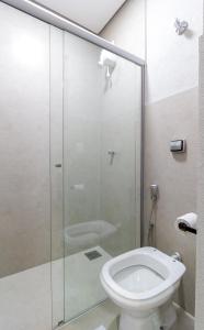 a bathroom with a glass shower with a toilet at MOOVE Stay - Suite Cacau no centro in Uberlândia
