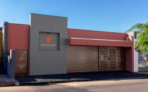 a building with a garage with a sign on it at MOOVE Stay - Suite Cacau no centro in Uberlândia +11 photos