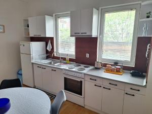 a kitchen with white cabinets and a white refrigerator at Atelier22 in Prilep +6 photos