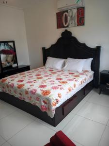 a bedroom with a bed with a floral comforter at New Kingston Condo Apt in Kingston +20 photos