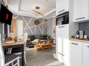a kitchen and living room with a couch and a table at Golden Apartments - Tatra View - Księżycowe Apartamenty SPA - 24d-1 in Zakopane