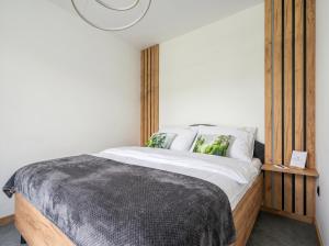 a bedroom with a bed with a wooden headboard at Golden Apartments - Tatra View - Księżycowe Apartamenty SPA - 24d-1 in Zakopane