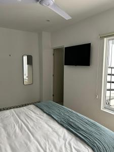 a bedroom with a bed and a flat screen tv at Casa Andres in Guadalajara