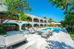 a resort with a pool and chairs and a building at The Courtyard - Poolside Suite in Boca in Boca Raton