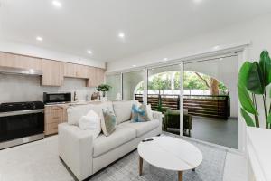 a living room with a white couch and a table at The Courtyard - Poolside Suite in Boca in Boca Raton