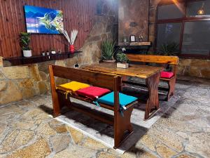 a wooden table and benches in a room at Hub 1001 Berat Hostel in Berat