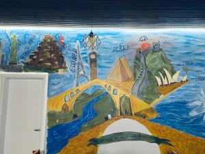 a mural of the wonders of the world on a wall at Hub 1001 Berat Hostel in Berat +22 photos