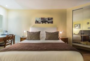 a bedroom with a large bed with a desk and a desk at Arcadie Montparnasse in Paris