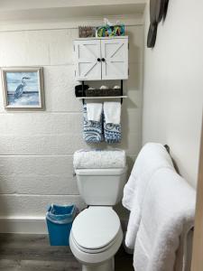 a bathroom with a white toilet and towels at Conch Shell Cabana in Vero Beach +18 photos