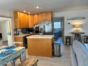 a kitchen with a stainless steel refrigerator and wooden cabinets at Conch Shell Cabana in Vero Beach