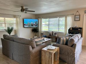 a living room with two couches and a flat screen tv at Conch Shell Cabana in Vero Beach