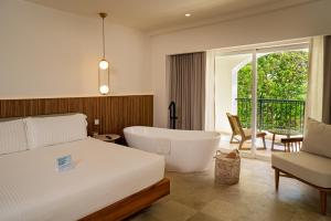 a bedroom with a tub and a bed and a chair at Kimpton Tres Rios - All Inclusive in Playa del Carmen +28 photos