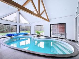 a large swimming pool in a room with windows at Harizou - Chalet & Piscine Intérieure in Saint-Pierre-la-Vieille