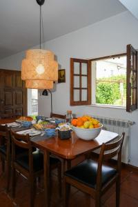a dining room table with a bowl of fruit on it at Casa da Pedrada in Ponte da Barca +23 photos