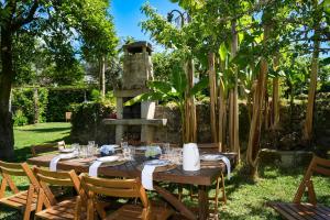 a table in a garden with a fireplace at Casa da Pedrada in Ponte da Barca