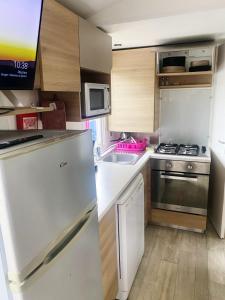 a small kitchen with a refrigerator and a sink at Mobile home in Litteau