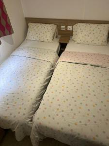 two beds sitting next to each other in a room at Mobile home in Litteau +5 photos
