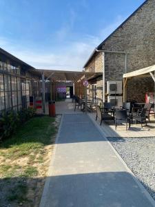 a walkway leading to a building with tables and chairs at Mobile home in Litteau