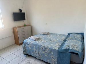 a bedroom with a bed and a dresser and a television at Loft Pedra Branca - Unisul in Palhoça