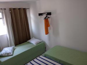 two twin beds in a room with a window at Espaço Jeito de Casa Hospedagem em Quarto Compartilhado in Recife