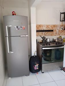 a kitchen with a refrigerator and a stove at Espaço Jeito de Casa Hospedagem em Quarto Compartilhado in Recife