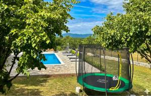 an empty trampoline next to a swimming pool at Stunning Home In Sinj in Sinj