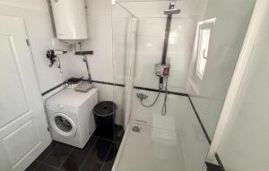 a small bathroom with a shower and a washing machine at Stunning Home In Sinj in Sinj