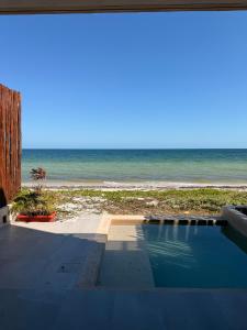 a swimming pool next to a beach with the ocean at Oceanfront Paradise Family Friendly in Telchac Puerto