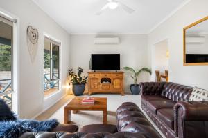 a living room with a couch and a flat screen tv at Salt & Stay - Laid-Back Comfort by the Beach in Encounter Bay