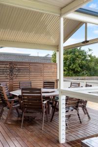 a patio with a table and chairs on a deck at Salt & Stay - Laid-Back Comfort by the Beach in Encounter Bay