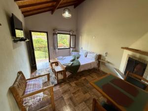 a living room with a bed and a fireplace at Villa da Vila Montanhas in Monte Verde