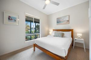 a white bedroom with a bed and a window at Salt & Stay - Laid-Back Comfort by the Beach in Encounter Bay