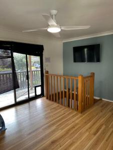 a living room with a ceiling fan and a wooden floor at Tranquil Waters Edge Escape in Sanctuary Point
