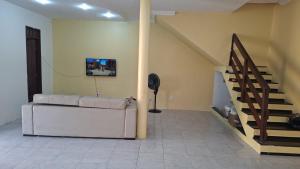 a living room with a couch and a staircase at Casa com 2 quartos em excelente localização in Juazeiro do Norte +28 photos
