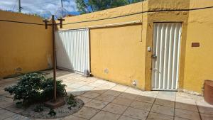 a yellow building with a garage with a door at Casa com 2 quartos em excelente localização in Juazeiro do Norte