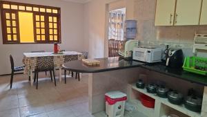 a kitchen with a table and a counter top at Casa com 2 quartos em excelente localização in Juazeiro do Norte