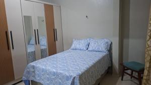 a bedroom with a bed with a blue comforter at Casa com 2 quartos em excelente localização in Juazeiro do Norte