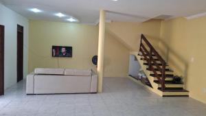 a living room with a couch and a staircase at Casa com 2 quartos em excelente localização in Juazeiro do Norte