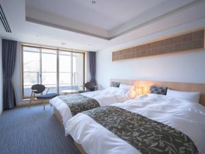 a hotel room with two beds and a window at さめうら荘レイクサイドホテル in Tosa