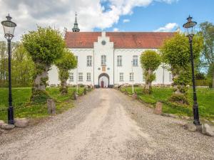 a large white building with a red roof at Holiday home in Marstal in Brovst