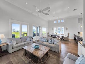 a living room with a couch and a table at Luxury Beachfront Ocean Views Pool Access Sleeps15 in Bolivar Peninsula
