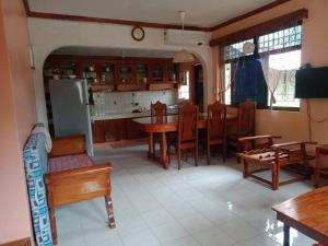 a kitchen and dining room with wooden tables and chairs at Ancestral BATO in Bato