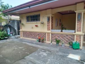 a house with potted plants in front of it at Ancestral BATO in Bato