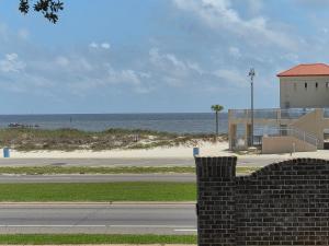 a brick wall next to a beach with a building and the ocean at Best location Cozy condo in Biloxi Beach in Biloxi