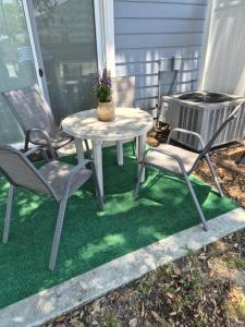 a patio table and chairs with a potted plant on it at Best location Cozy condo in Biloxi Beach in Biloxi +2 photos