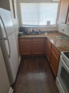 a kitchen with wooden cabinets and a white refrigerator at Best location Cozy condo in Biloxi Beach in Biloxi