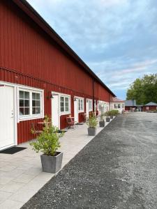 a red barn with potted plants in front of it at Närebo Gårdshotell in Lidköping